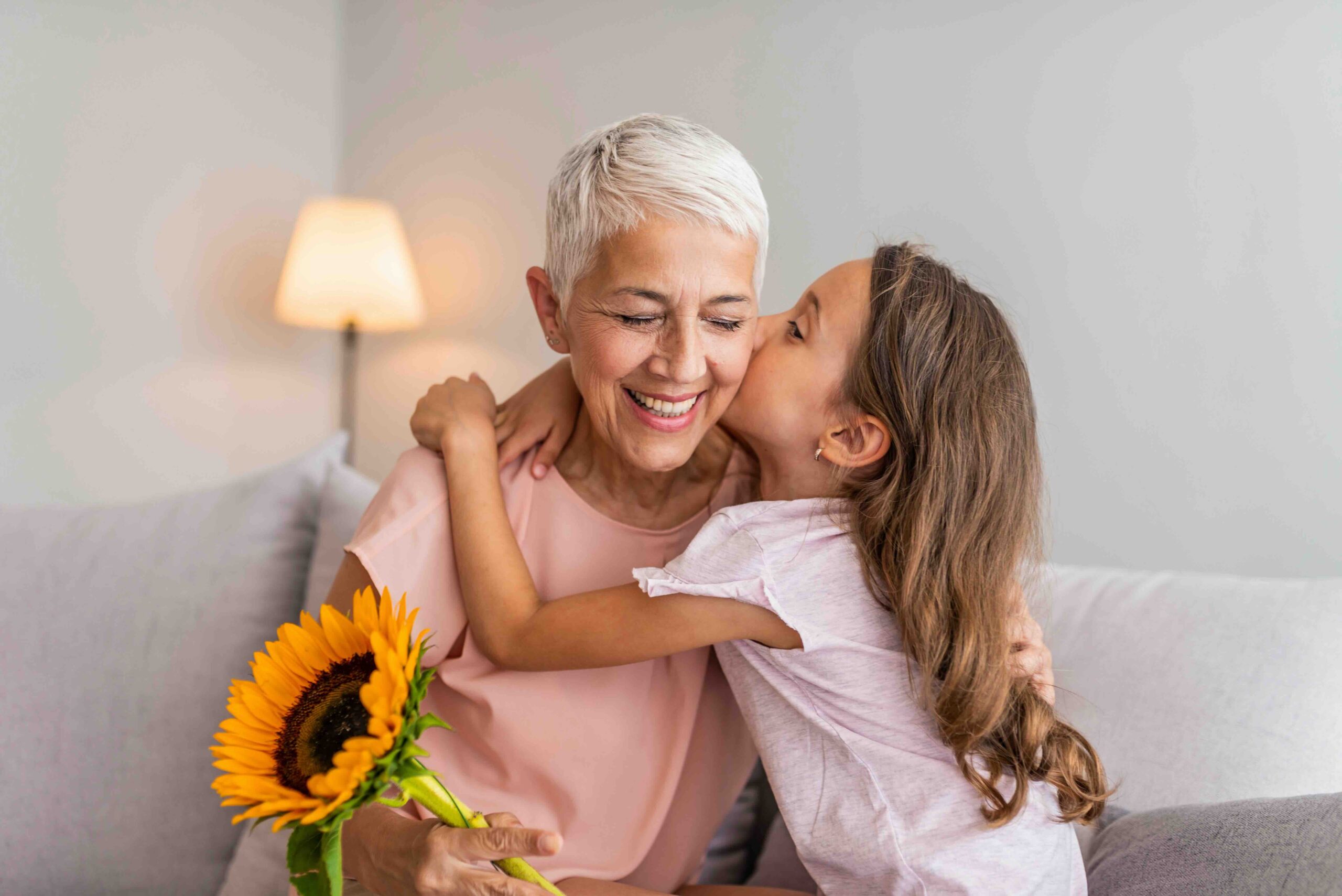 grand daughter kissing her grandmother